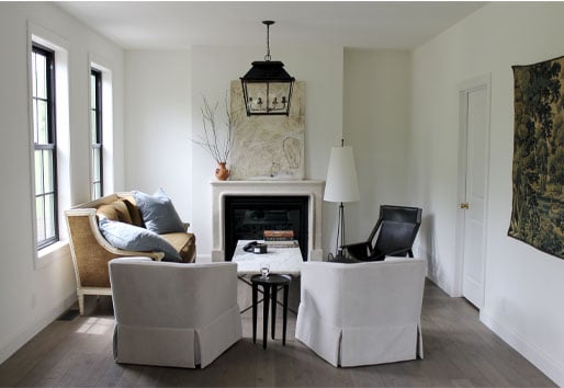 A limestone fireplace and lantern-style light fixture are the central elements in this European farmhouse living room.