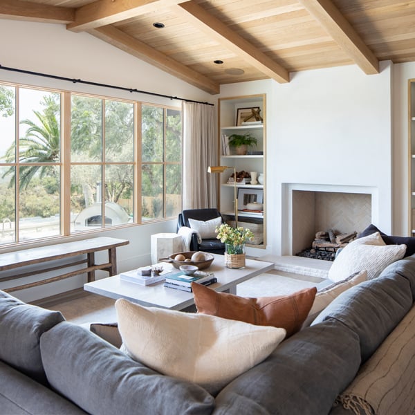 cozy living room with large windows, wood ceiling, and a fireplace