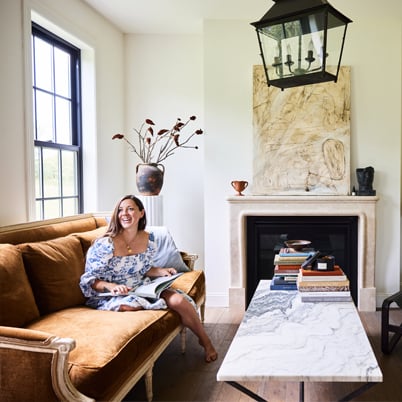 Young woman sitting on a couch in front of hung window